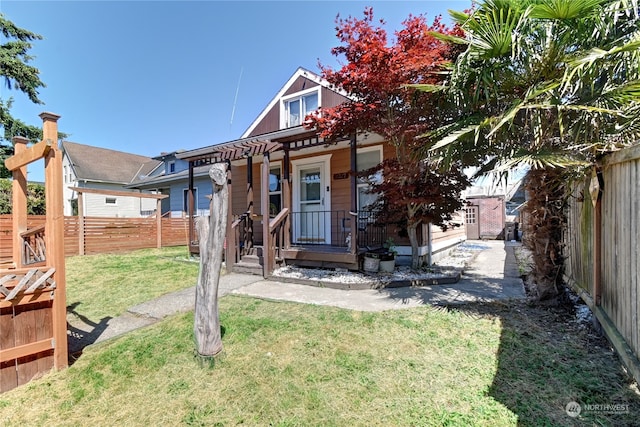 back of property featuring a yard and covered porch