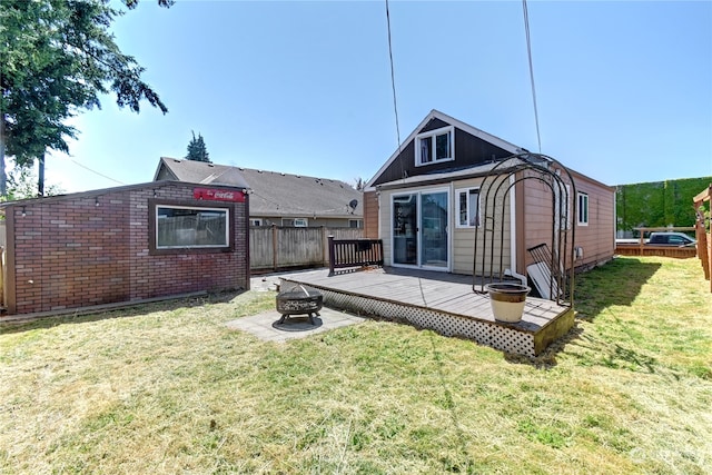 back of house with a deck and a lawn