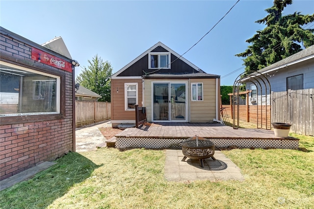 back of property featuring a deck and a lawn