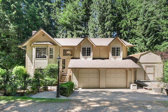 view of front facade featuring a garage and a shed