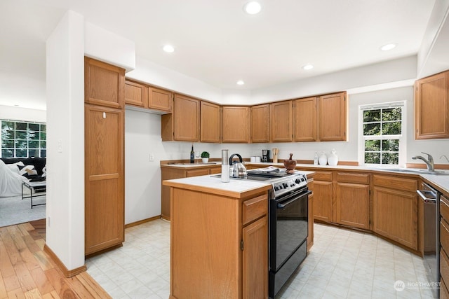 kitchen featuring black stove, a kitchen island, stainless steel dishwasher, and sink