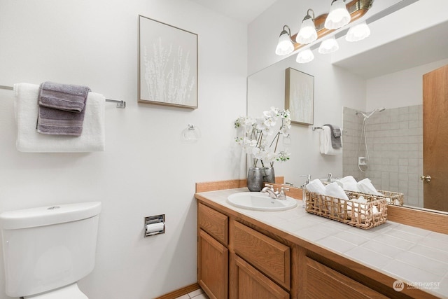 bathroom featuring vanity, toilet, and tiled shower