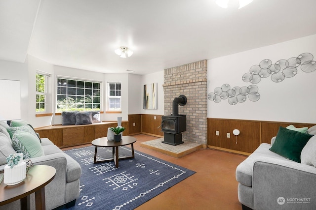 carpeted living room featuring a wood stove and wood walls