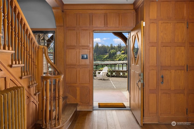 foyer featuring stairs, radiator heating unit, and wood finished floors