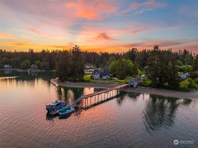 view of dock with a water view and a forest view