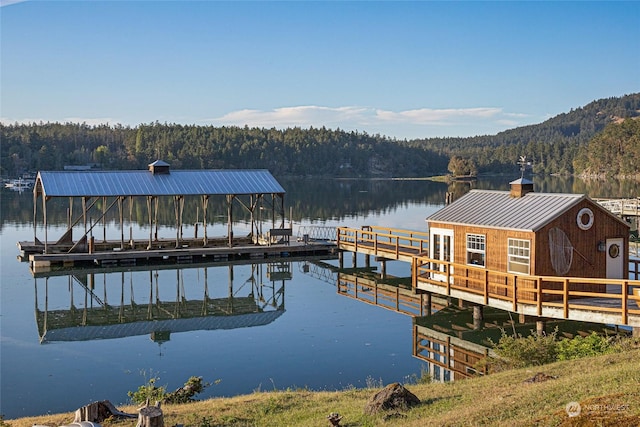 dock area featuring a forest view and a water view