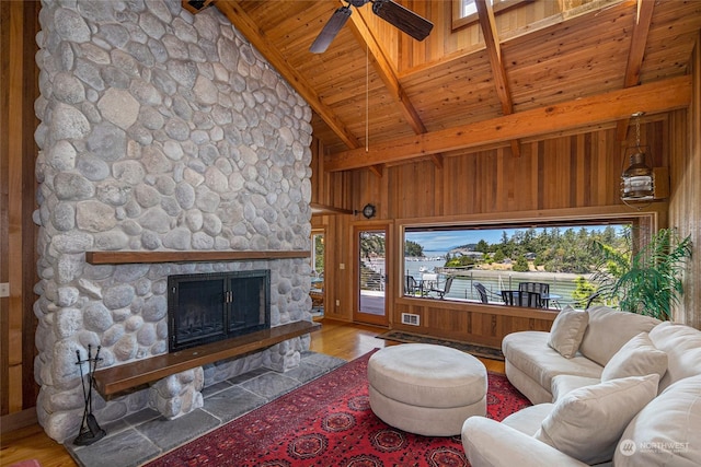 living room featuring a fireplace, wood ceiling, wooden walls, wood finished floors, and beamed ceiling