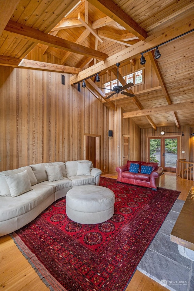 living area featuring wooden ceiling, wooden walls, high vaulted ceiling, and beam ceiling