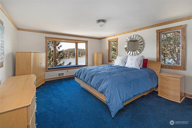 carpeted bedroom featuring ornamental molding, a water view, visible vents, and baseboards