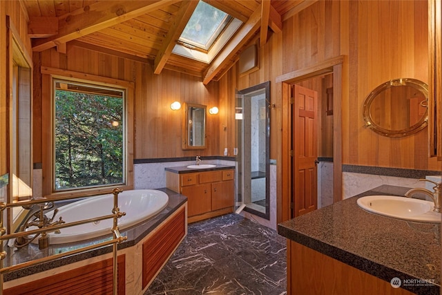 full bath with lofted ceiling with skylight, marble finish floor, a sink, and wooden walls