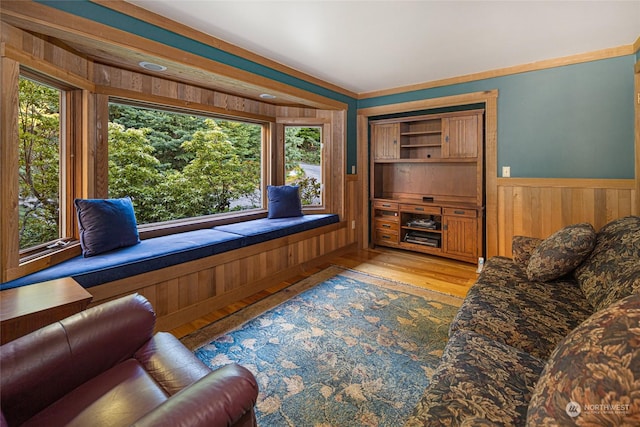 living area featuring wainscoting and wood finished floors