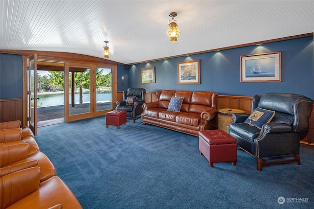 living area featuring vaulted ceiling, wainscoting, carpet, and a water view