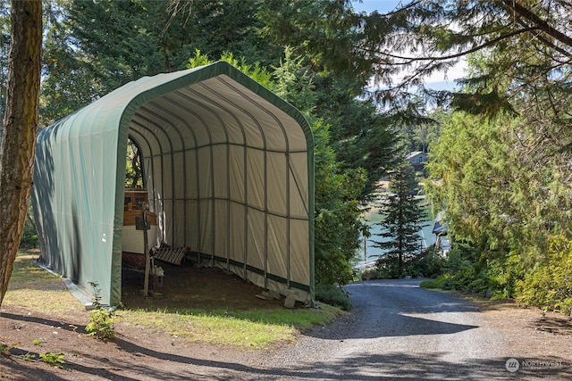 view of outbuilding with gravel driveway and a detached carport