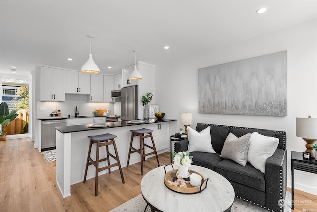 living room with sink and light hardwood / wood-style flooring