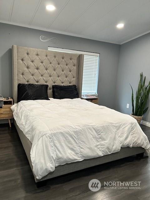 bedroom with dark hardwood / wood-style floors and crown molding