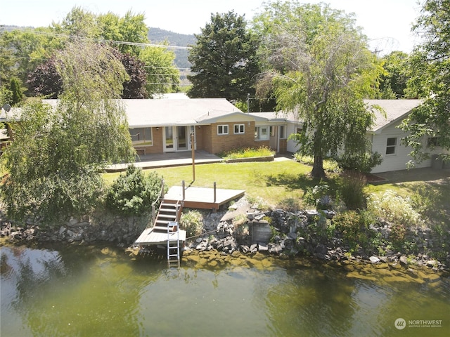 exterior space featuring a patio, a water view, and a lawn