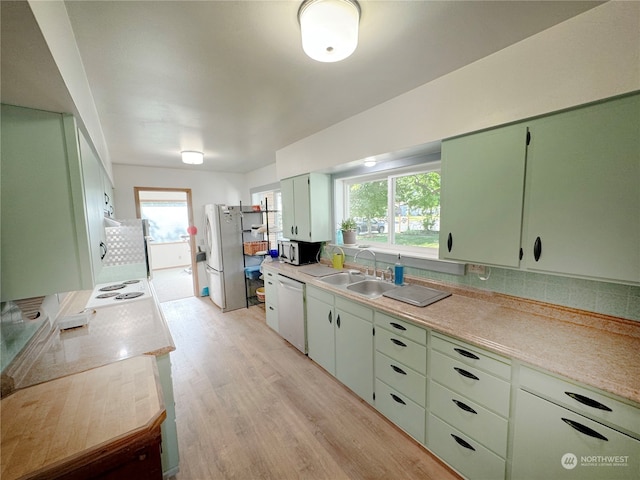 kitchen with stainless steel appliances, light hardwood / wood-style floors, sink, and plenty of natural light