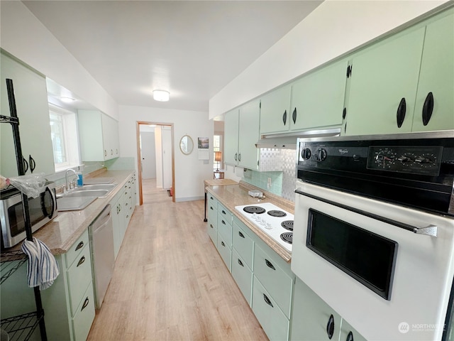 kitchen featuring light hardwood / wood-style flooring, tasteful backsplash, green cabinetry, appliances with stainless steel finishes, and sink