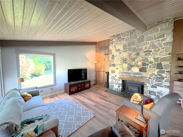 living room featuring a stone fireplace, wood walls, hardwood / wood-style floors, and wooden ceiling