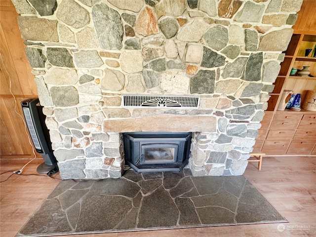 details with wood walls, a wood stove, and hardwood / wood-style flooring