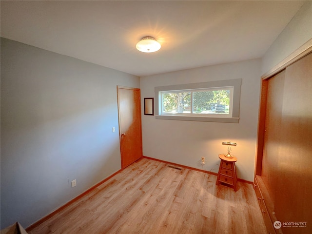 unfurnished bedroom with hardwood / wood-style flooring and a closet