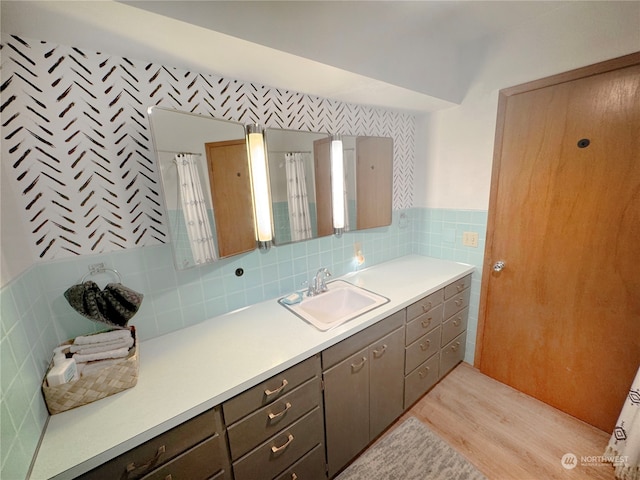 bathroom featuring hardwood / wood-style flooring, backsplash, vanity, and tile walls