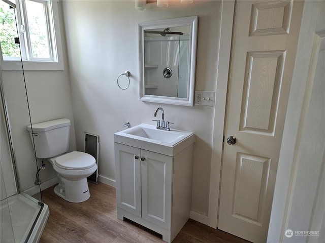 bathroom with vanity, wood-type flooring, toilet, and walk in shower