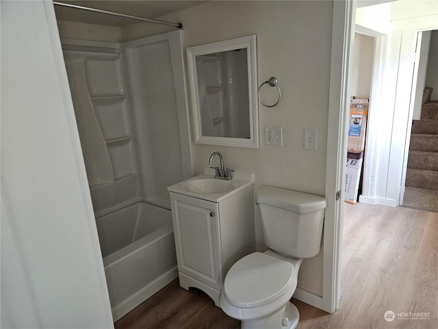 full bathroom with vanity, hardwood / wood-style floors, washtub / shower combination, and toilet