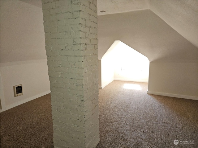 bonus room with vaulted ceiling and carpet flooring