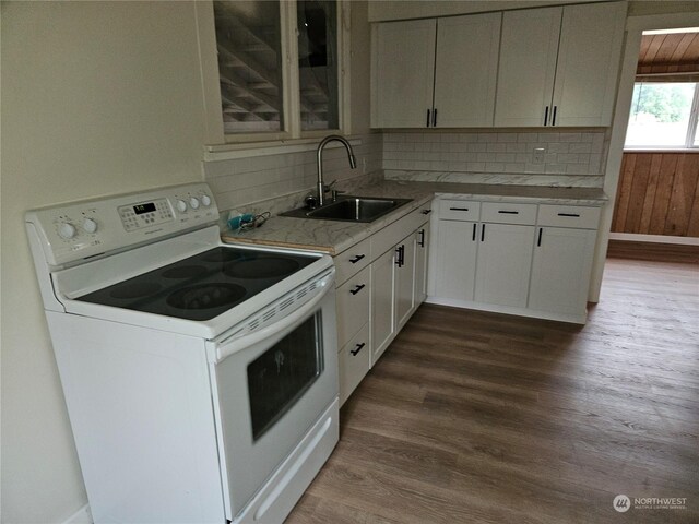 kitchen with tasteful backsplash, wood-type flooring, sink, white cabinets, and white range with electric cooktop