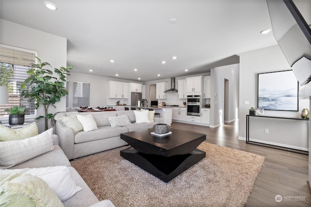 living room featuring sink and light hardwood / wood-style flooring