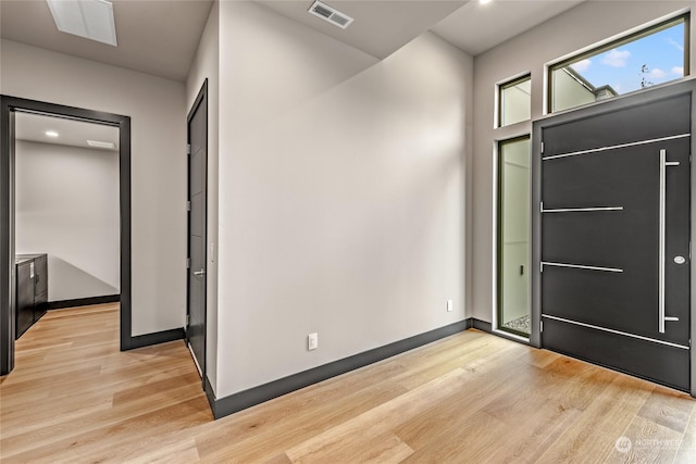 entryway with light wood-type flooring, baseboards, and visible vents