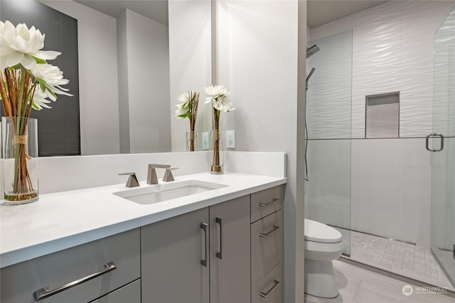 bathroom featuring vanity, toilet, and a shower stall