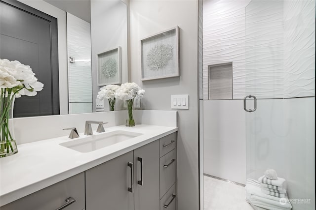 bathroom with a shower with shower door and vanity