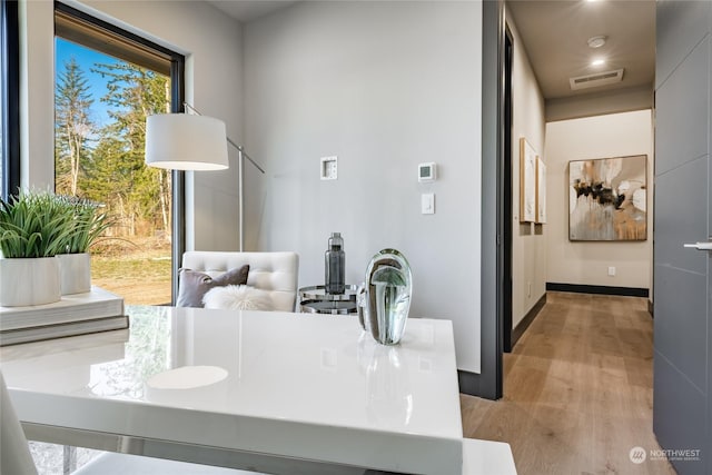 dining room featuring baseboards, light wood-style floors, and visible vents