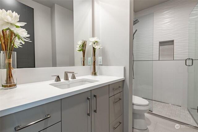 bathroom with vanity, tile patterned floors, toilet, and walk in shower