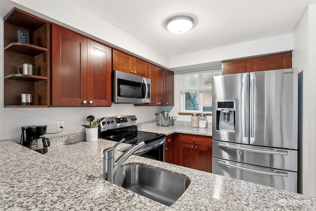 kitchen with light stone countertops, sink, and appliances with stainless steel finishes