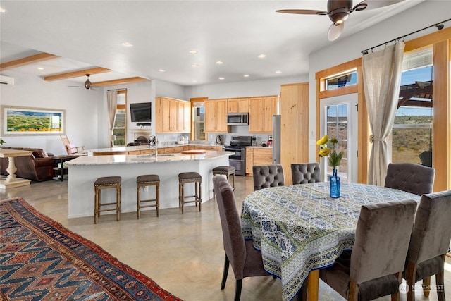 dining area with ceiling fan, a wall mounted air conditioner, and sink