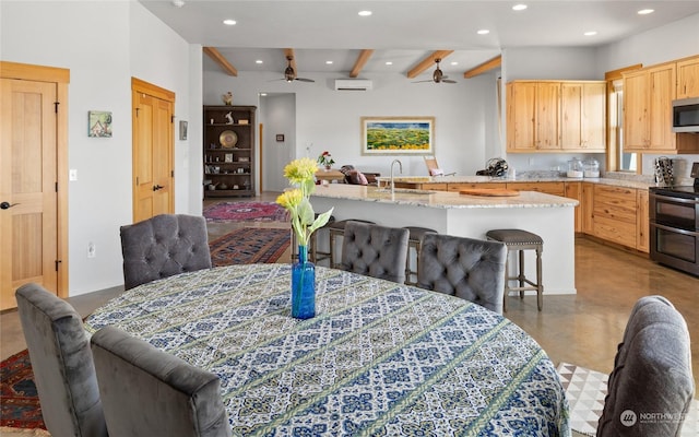 dining space with beamed ceiling, sink, a wall unit AC, and ceiling fan