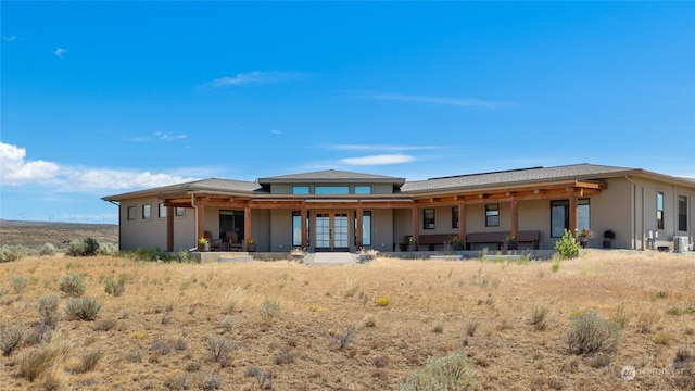 rear view of property featuring central AC unit and french doors