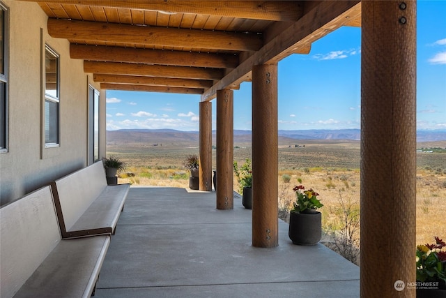 view of patio / terrace with a mountain view and a rural view