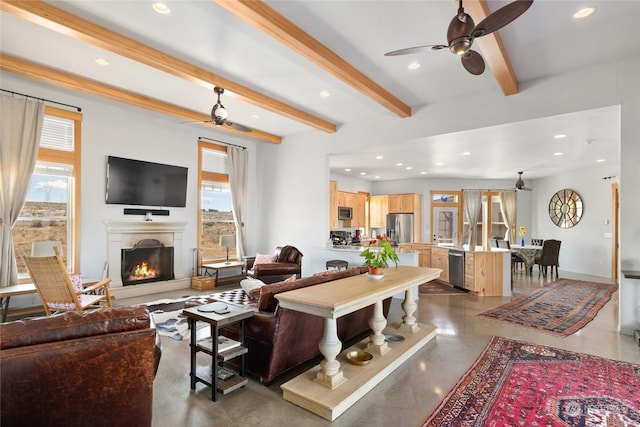 living room with beamed ceiling, ceiling fan, and plenty of natural light