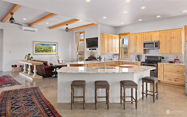 kitchen with light brown cabinetry, sink, a kitchen breakfast bar, and appliances with stainless steel finishes