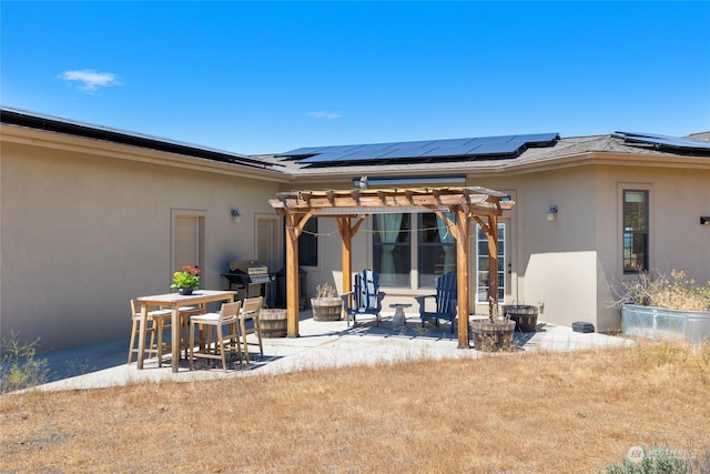 back of house with a pergola, a patio, and solar panels