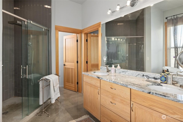 bathroom with concrete flooring, vanity, and a shower with shower door