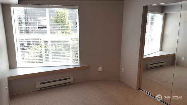 carpeted spare room featuring a baseboard radiator