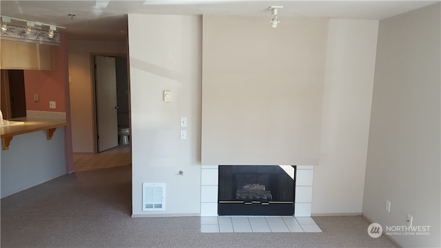 unfurnished living room featuring a fireplace and tile patterned flooring