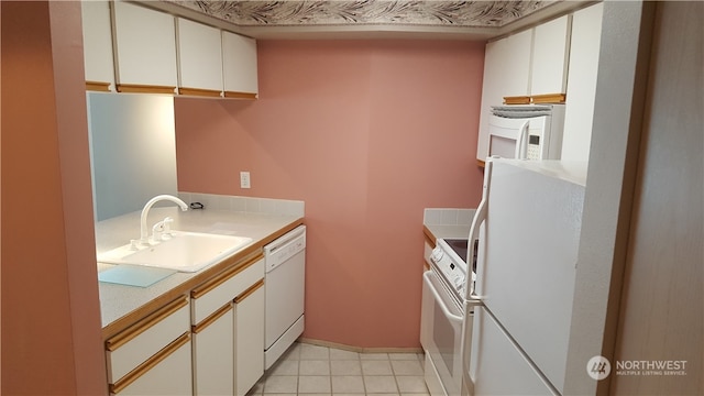 kitchen featuring white cabinets, light tile patterned floors, white appliances, and sink