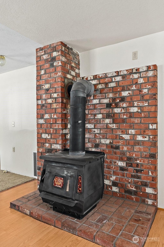 details featuring hardwood / wood-style floors, a textured ceiling, and a wood stove