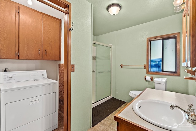 bathroom with washer / clothes dryer, vanity, an enclosed shower, and toilet